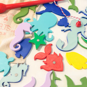 חלקי משחק מגנטיים בצורת יצורי ים על רקע לבן עם חכה אדומה